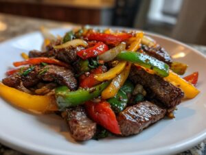 Close-up of juicy steak fajitas strips mixed with colorful sautéed bell peppers (red, green, yellow) and onions on a white plate.