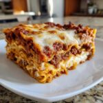 A generous slice of Lasagna with Cottage Cheese, showing layers of pasta, meat sauce, and white cheese filling.