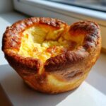 A single, perfectly risen yorkshire pudding with golden-brown, crisp edges and a soft, fluffy center.