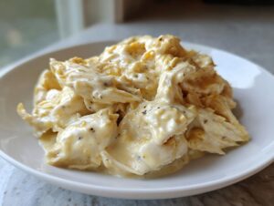 Shredded chicken coated in a rich, creamy Parmesan sauce, ready to serve as slow cooker garlic parmesan chicken.
