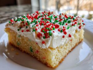 A close-up of a square slice of moist christmas sugar cookie bars topped with thick white frosting and red, green, and white sprinkles.
