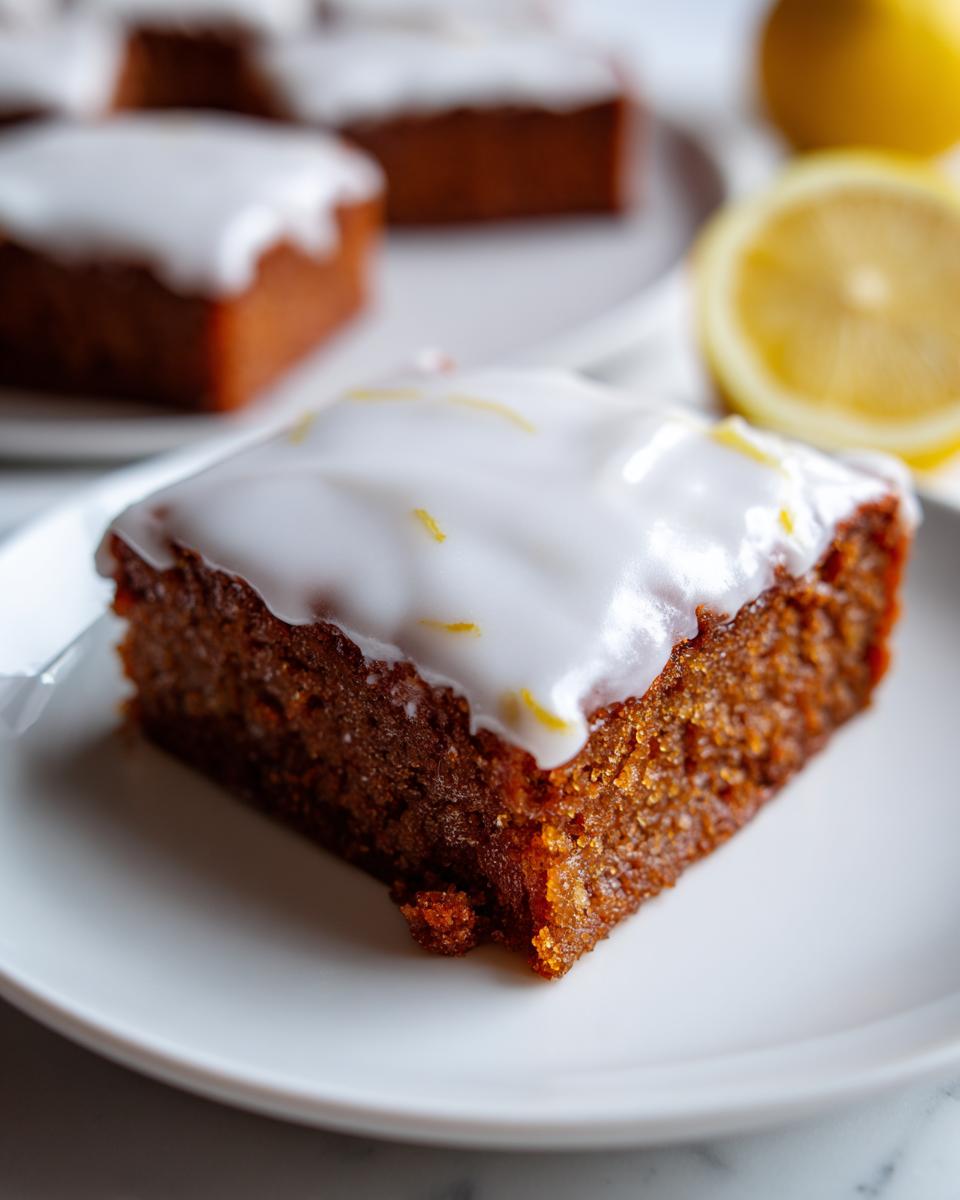 Close-up of a fudgy Lemon Brownies square topped with thick white glaze and lemon zest.