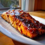 A perfectly cooked fillet of salmon with a dark, shiny glaze, ready to serve from this baked salmon recipe.