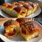 Close-up of gooey, cheesy pizza sliders filled with pepperoni, topped with garlic butter and herbs.