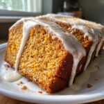 Two moist slices of sweet potato pound cake topped with thick vanilla glaze and orange zest.