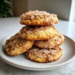 A stack of four moist coffee cake cookies topped with cinnamon streusel and a light vanilla glaze.